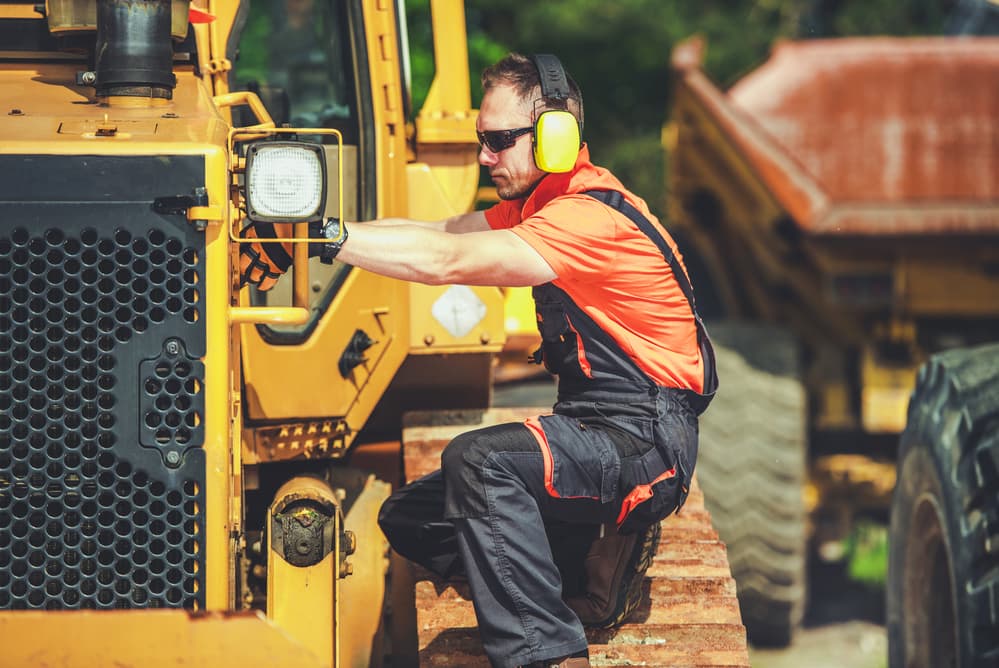 man inspecting heavy equipment