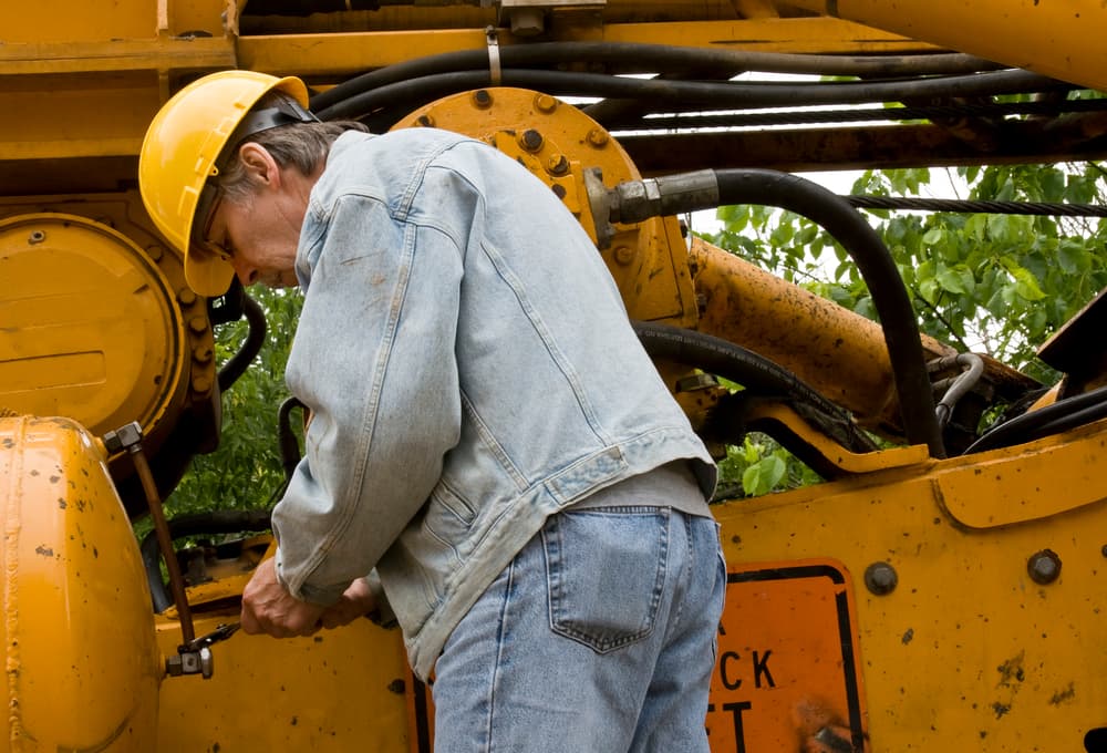 construction equipment mechanic performing an inspection of used equipment