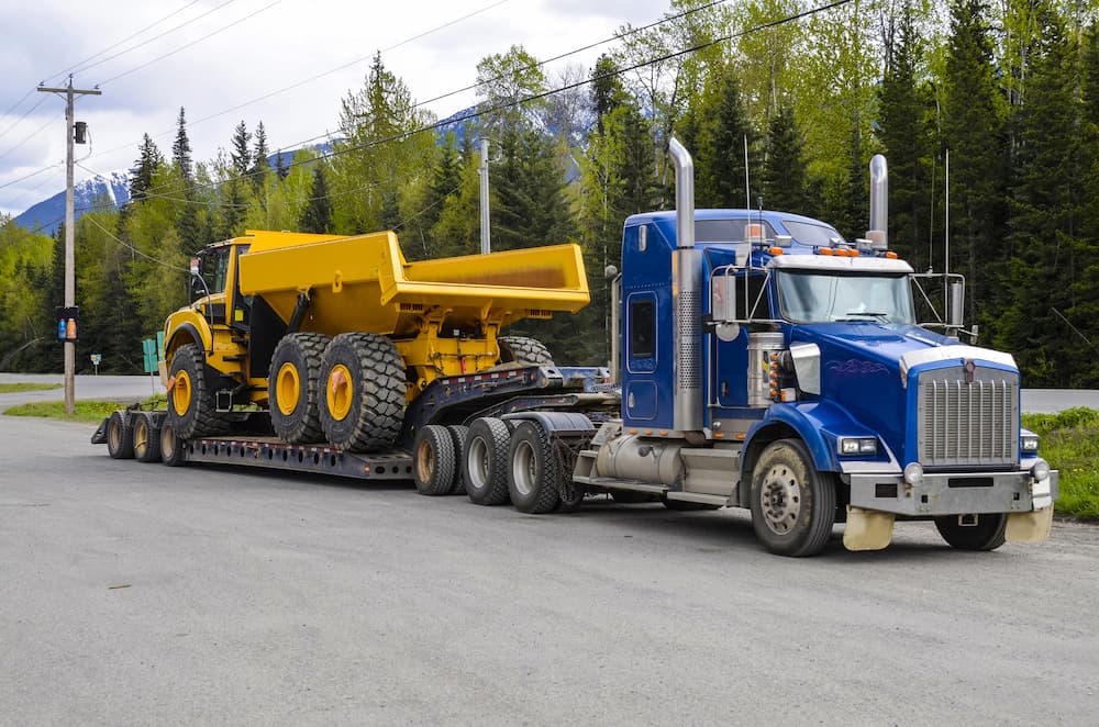 importing heavy equipment dump truck on trailer