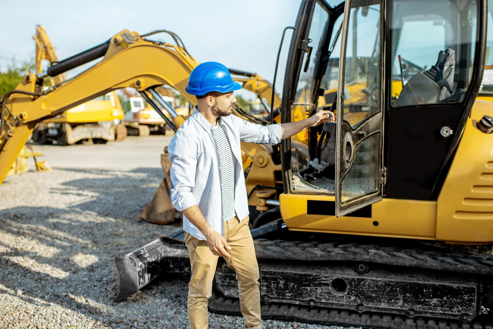 man visually inspecting heavy equipment before auction