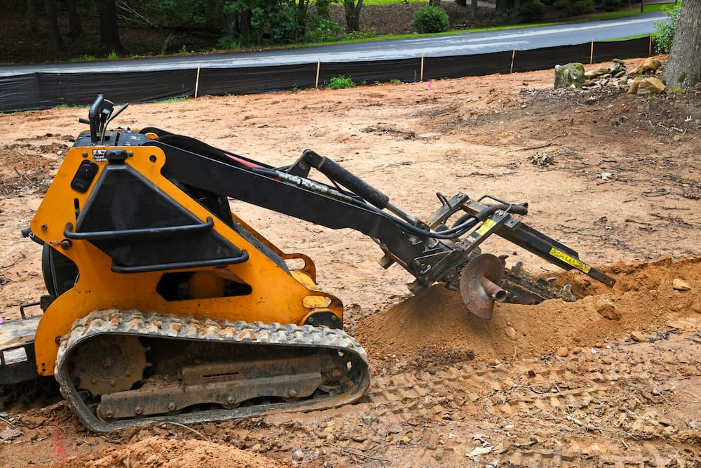 Trencher digging French drain trench