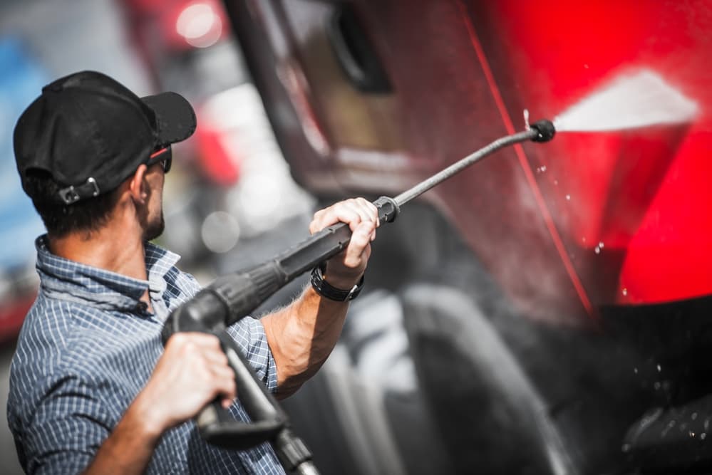 man power washing semi truck before listing it for sale