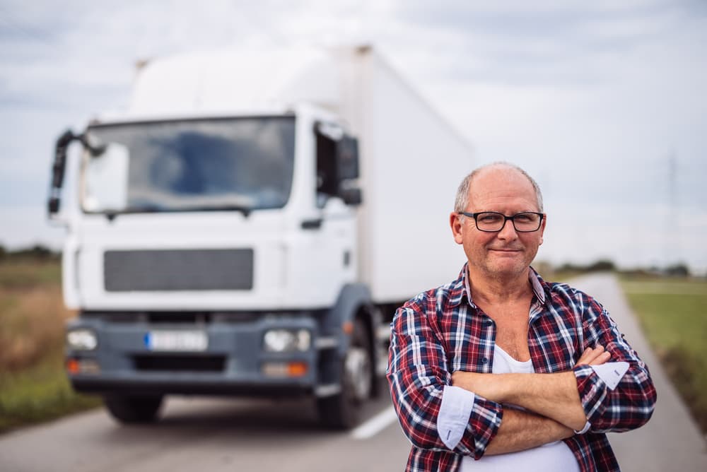 happy truck driver man standing in front of semi truck