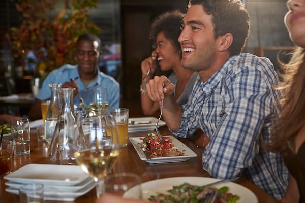 friends eating meal together laughing