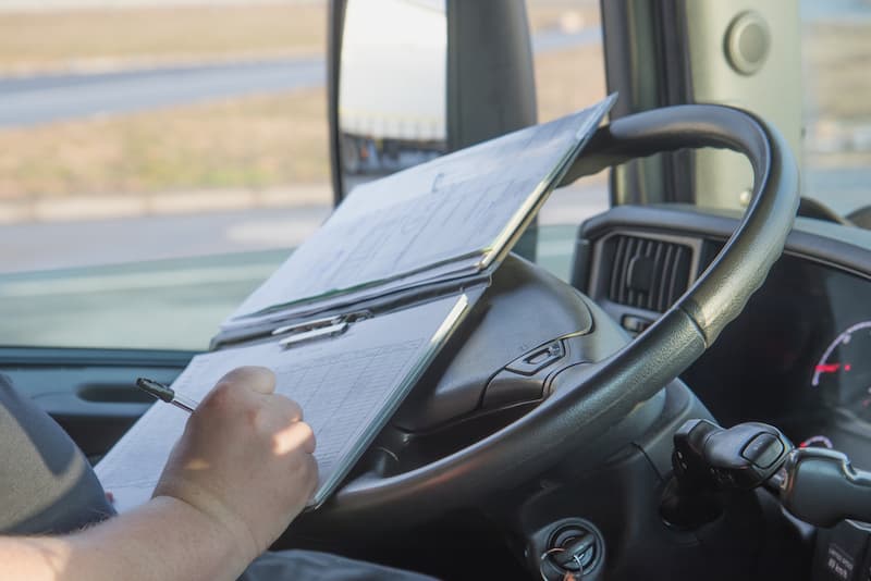 semi truck driver logging mileage documentation in log book