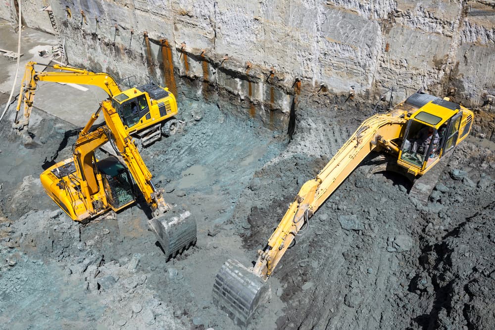 three excavators digging